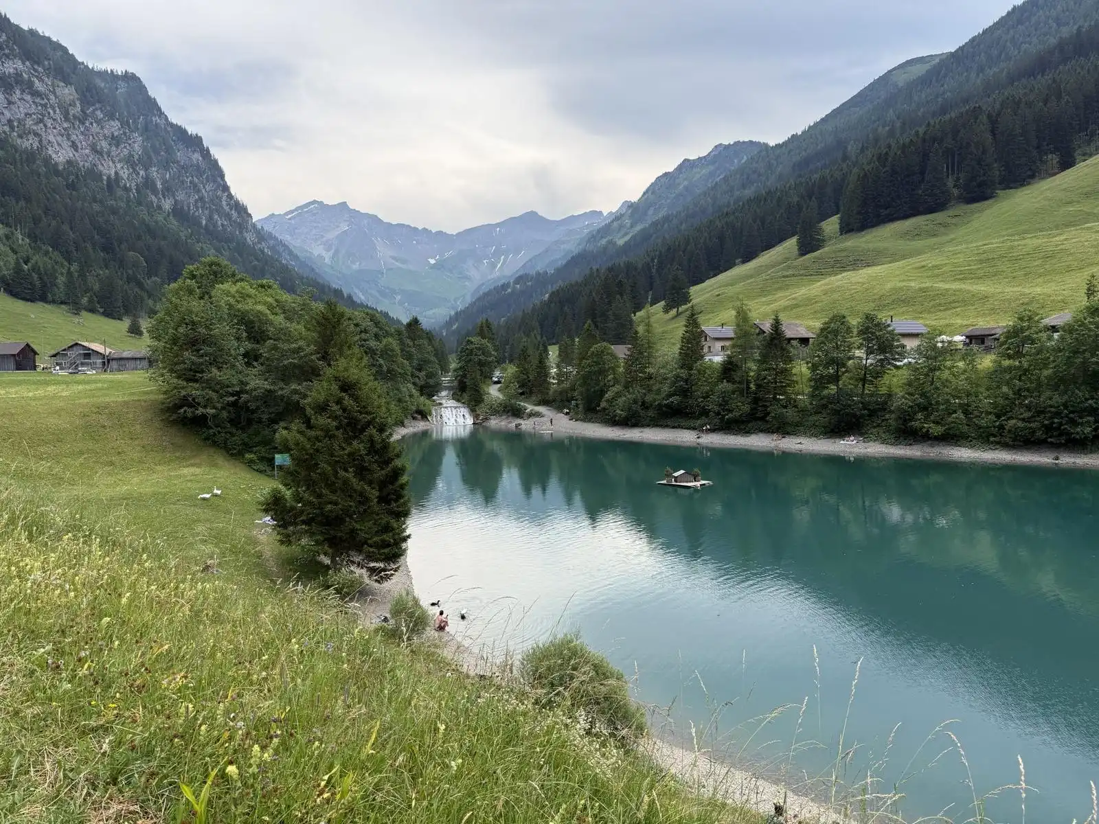 A turquoise lake below steep forested slopes in the Alps, scouted for a July elopement